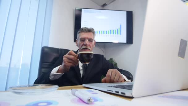 Businessman beve caffè mentre guarda lo schermo del computer portatile — Video Stock