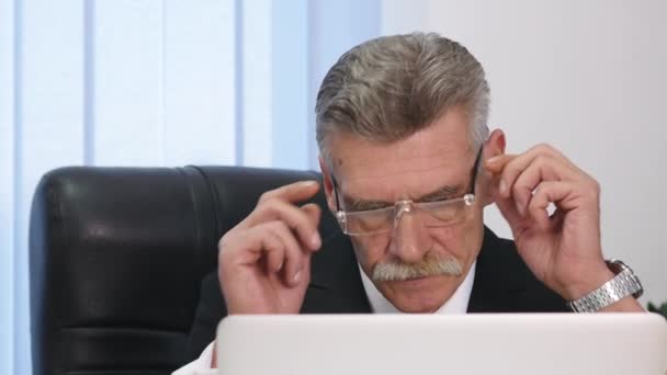 Empresário com dor de cabeça durante o trabalho no escritório — Vídeo de Stock