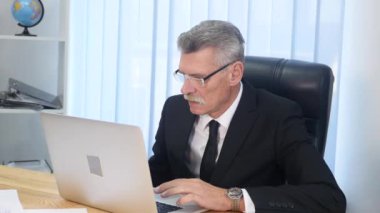 yaşlı işadamı modern ofis içinde bilgisayar ile çalışma