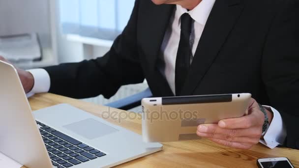 Zakenman handen te typen op laptopcomputer in houten tafel en enkele aantekeningen te maken. Slow motion — Stockvideo