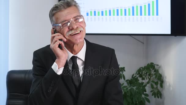 Geschäftsmann telefoniert im Büro vor Schreibtisch — Stockvideo