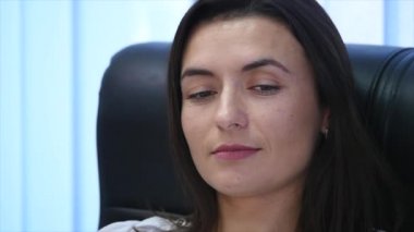 Office bir koltukta oturan emin olgun işkadını. Kadın yöneticisi Office kameraya bakıyor. ağır çekim