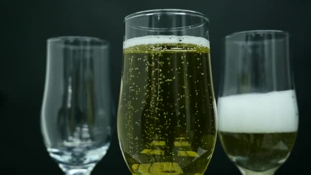 Бокалы шампанского с пузырьками изолированы на черном фоне — стоковое видео