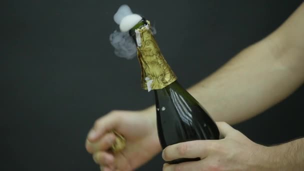Взрыв шампанского. Мужская рука открывает бутылку шампанского крупным планом. Игристые вина на праздничном фоне. Бутылка шампанского. Успехов в праздновании. Медленное движение — стоковое видео