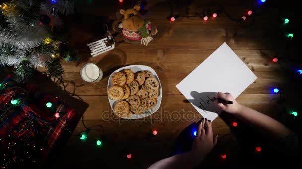 Noël et Nouvel An fond. Les mains d'un homme prennent des notes. Vue du dessus . — Video