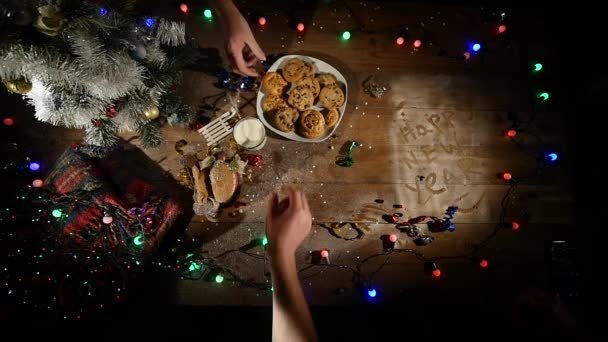 Vista dall'alto. Tavolo marrone in legno decorato con roba natalizia e ghirlande. Luci rosse di Natale. Da vicino. — Video Stock
