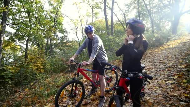 Een vrouw en een man met een fiets een herfstdag — Stockvideo