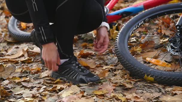 Mujer en forma activa atando zapatos en el parque. cámara lenta — Vídeo de stock