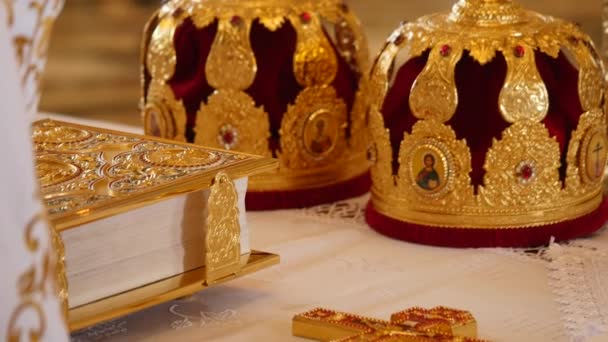 Atributos da igreja para cerimônia de casamento. Coroas de ouro estão no altar. Atributos do padre. Interior da igreja — Vídeo de Stock