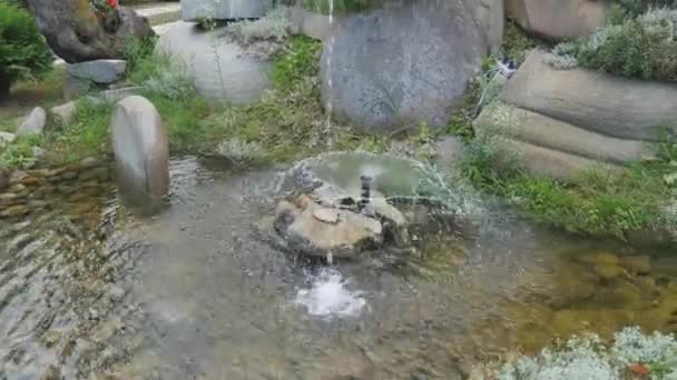 Close-up of the artificial waterfall in the park, clear water runs along the stone steps — Stock Video