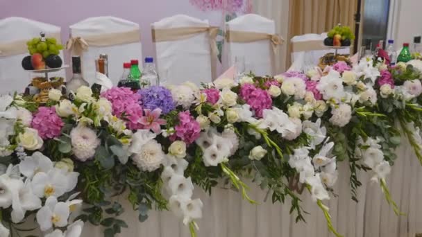 Decoración de la tabla de la boda con las flores, tabla de la boda de la decoración de la flor, florista de la boda, boda en la mesa es Pano con letras y monogramas, flores de la rosa y orquídea blanca — Vídeos de Stock