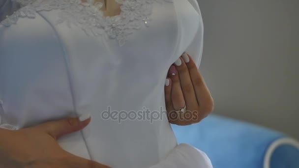 La novia lleva un vestido de novia en la habitación del hotel . — Vídeos de Stock