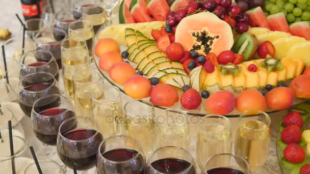 Különböző friss gyümölcsök esküvő büfé asztal. Gyümölcsök és bogyók esküvői asztaldísz. Svédasztalos fogadás gyümölcs borok champagne. Esküvői teríték — Stock videók