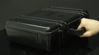 Bir adam bir siyah metal çanta para ile açar.