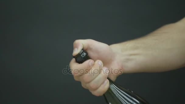 Explosion de champagne. Homme main ouverture bouteille de champagne gros plan. Vin mousseux pendant les vacances Bokeh fond clignotant. Bouteille de champagne en gros plan. Célébration du succès. Mouvement lent 