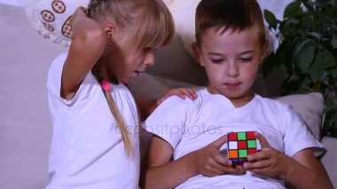 kız çocuk Rubiks küp toplamak için yardımcı olur.