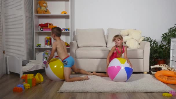 Menino e menina pulando em bolas infláveis — Vídeo de Stock