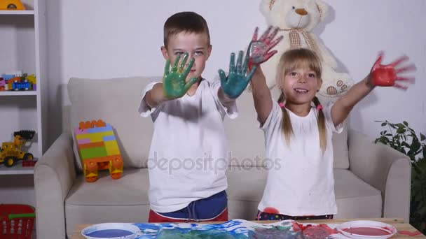 Девочка и мальчик показывают руки в краске — стоковое видео