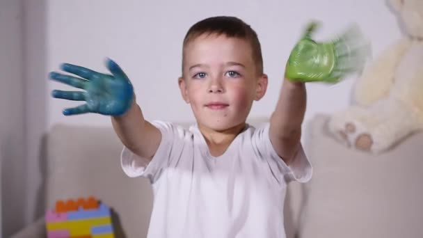 Мальчик размахивает руками в краске, замедленная съемка — стоковое видео