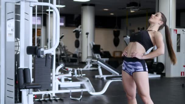 Молодая женщина делает упражнения в тренажерном зале — стоковое видео