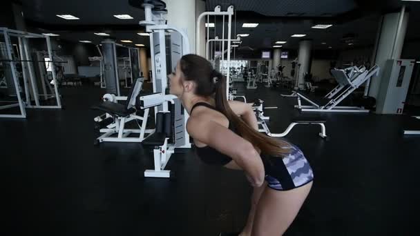Jonge vrouw doen van de oefeningen in de sportschool — Stockvideo