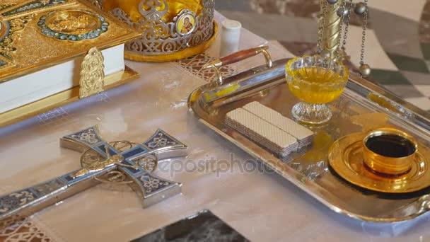 Atributos da igreja para cerimônia de casamento. Coroas de ouro estão no altar. Atributos do padre. Interior da igreja — Vídeo de Stock