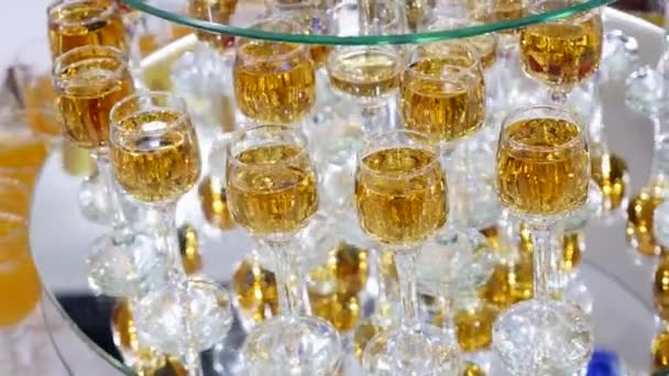 杯子里有酒精和不同的饮料, 酒杯和香槟都在自助餐桌上, 红酒在杯子里, 香槟在玻璃上, 自助餐桌上有酒 — 图库视频影像