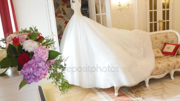 Vestido de novia esponjoso en una percha en la habitación de hotel. Mañana de boda — Vídeo de stock