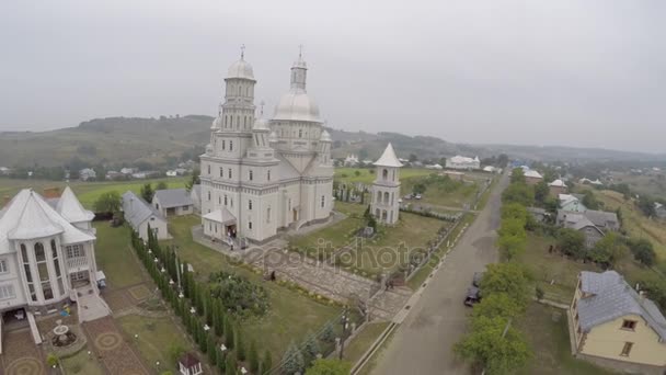 Aérea: Drone tiro del paisaje con la iglesia. Las novias van a la iglesia — Vídeos de Stock