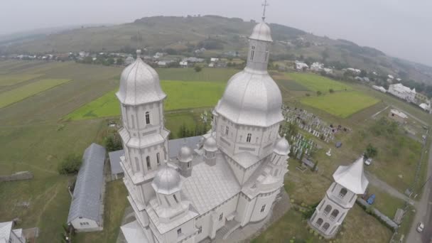 Antenn: Drone fotografering av landskap med kyrka. Brudar gå till kyrkan — Stockvideo