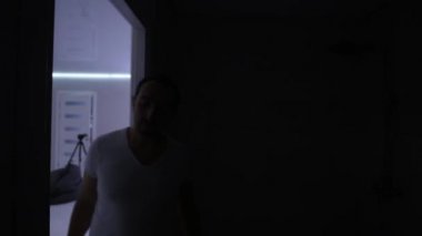 Genç adam banyoda Elektrikli tıraş makinesi ile sakalını tıraş