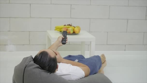 Man kijken Tv Green In de kamer en het eten van een appel — Stockvideo