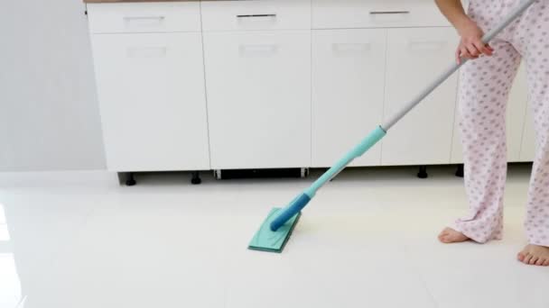 Mujer limpiando pisos de parquet en la cocina. Primer plano — Vídeos de Stock