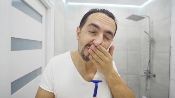 Человек бреется перед зеркалом — стоковое видео