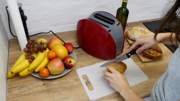 Una mujer cortando una barra de pan con un cuchillo de pan — Vídeos de Stock