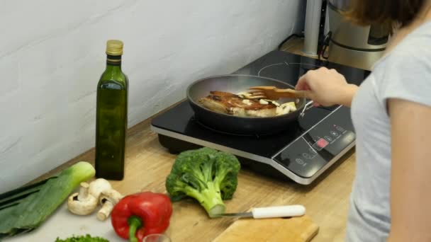 Delicioso bistec colocado en la parrilla caliente decorado con sal y pimienta. Freír filete carne cruda de res. la carne se fríe la mantequilla y se calienta en una sartén — Vídeo de stock