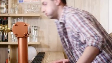 Genç adam bir barın arkasında içki bira sayaç