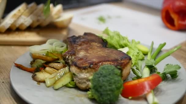 Verse warme gegrilde vlees biefstuk op plaat over houten tafel — Stockvideo