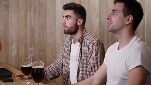 Deux amis masculins assis sur le canapé et regarder le sport à la télévision — Video