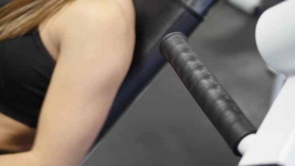 Mujer entrena brazos y hombros en simulador en gimnasio — Vídeos de Stock