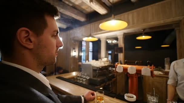 Un bel giovanotto che sorseggia un drink in un bar. Stile di vita concetto — Video Stock