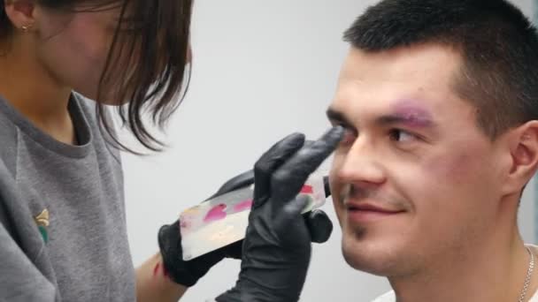 Візажист на роботі, застосовуючи макіяж спеціальних ефектів — стокове відео