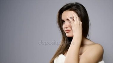 Studio poz genç güzel esmer kadın. Güzel bir kadının moda portre. Uzun kahverengi saçlı gri arka plan üzerinde izole neşeli kadın