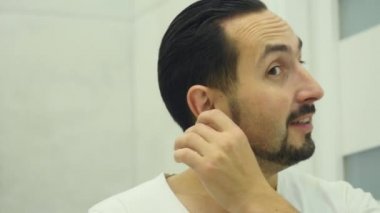 Genç erkek temizlik kulak bir pamuk bez ile yakın Up-Shot