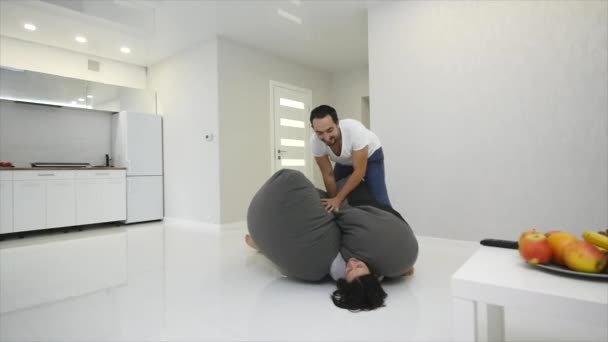 4K Casal lutando pelo controle remoto na frente da TV — Vídeo de Stock