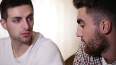 İki genç erkek arkadaş otururken bar ve birbirleri ile bira yudumlarken konuşuyor.