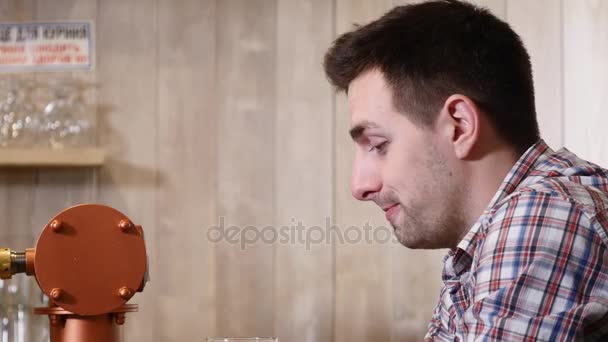 Young man drinks beer behind a bar counter — Stock Video