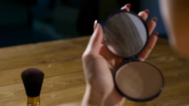 Cep aynaya bakıp kendini hayran kadın. Kadın ona makyaj küçük cep aynası içinde kontrol. Bir cep aynası gülümseyen kadın