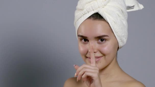 Mujer bella con una toalla en la cabeza moviendo la cabeza y sonriendo — Vídeos de Stock