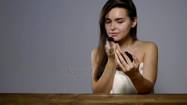 Girl holding powder brush in her hand and it pours her face — Stock Video